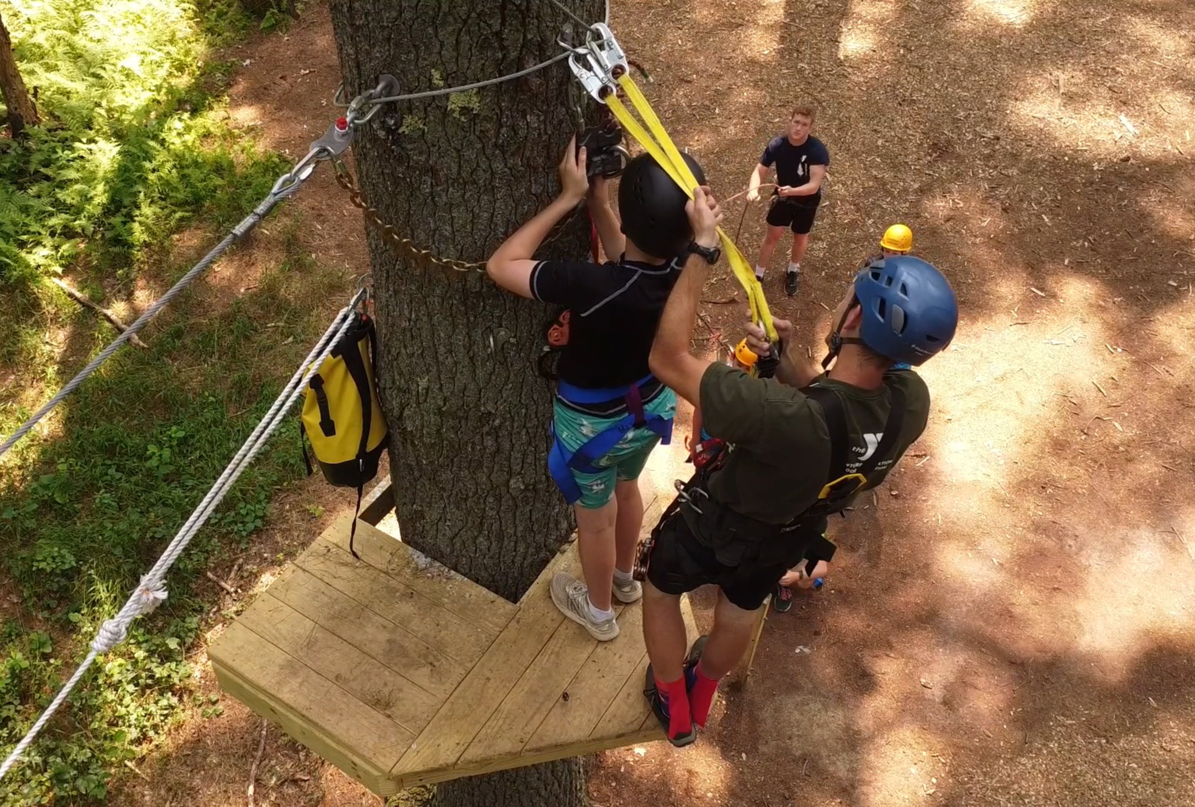 close up aerial image of two people on a zipline platform