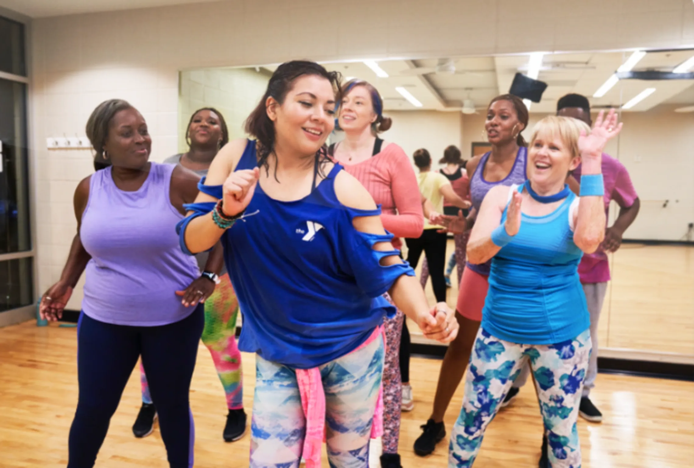 Group of women joyfully dancing in Zumba class