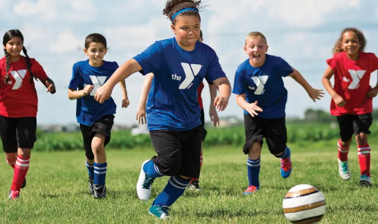 middle school aged kids playing soccer in a field