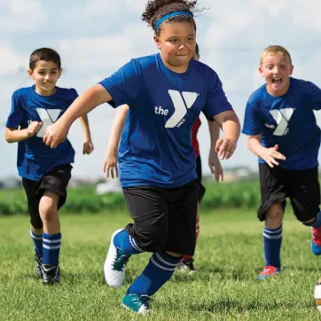 middle school aged kids playing soccer in a field