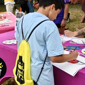 Little boy draws a picture at the Summer Eats kickoff event